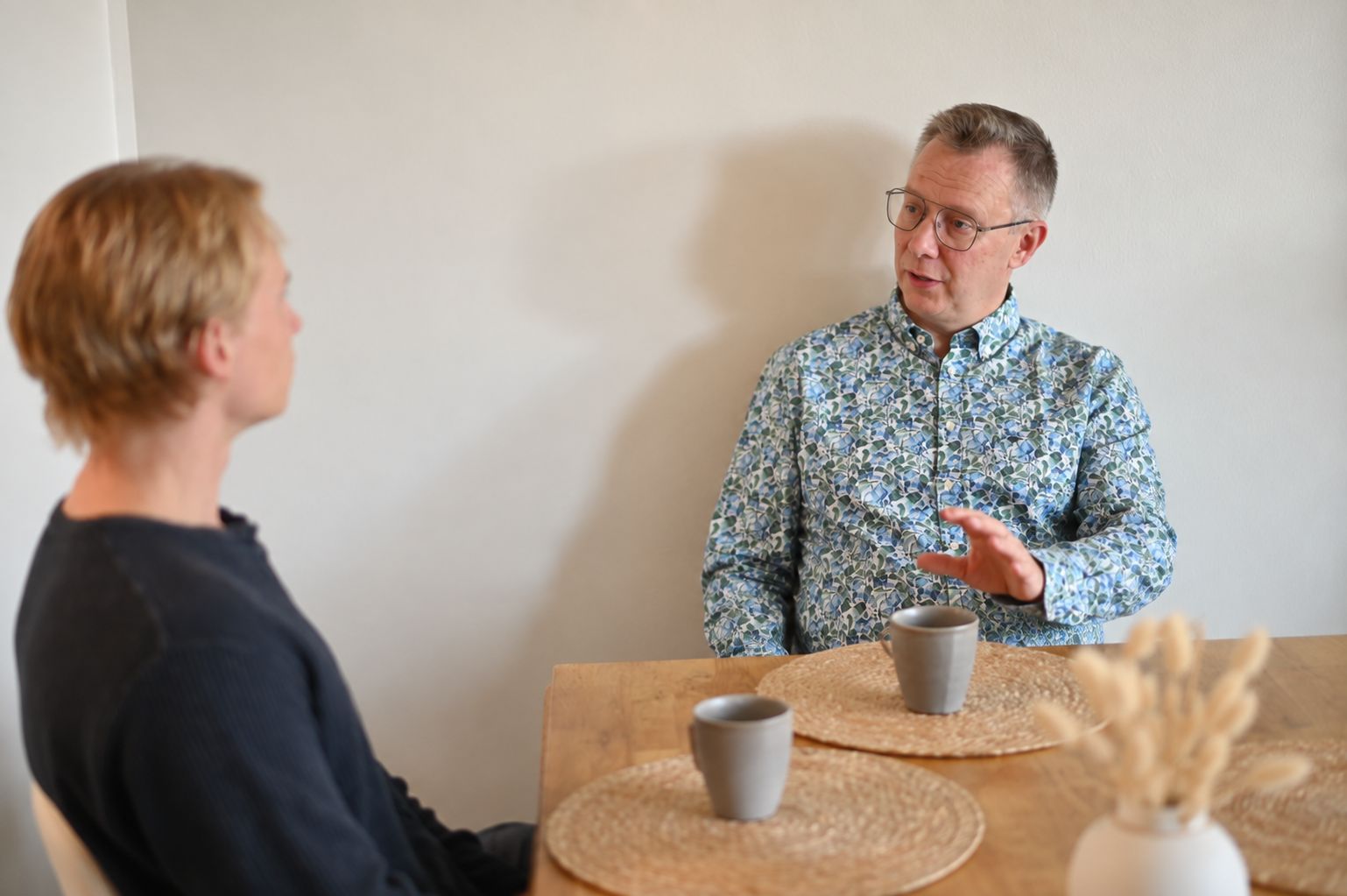 Timo Kurikka keskustelee asiakkaan kanssa pöydän ääressä